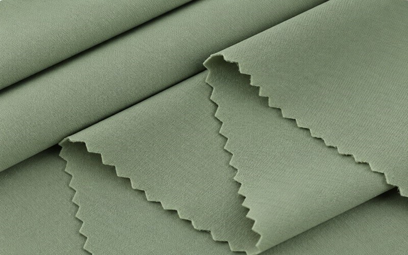 Sage green fabric folds and swatches for custom yoga bra material selection