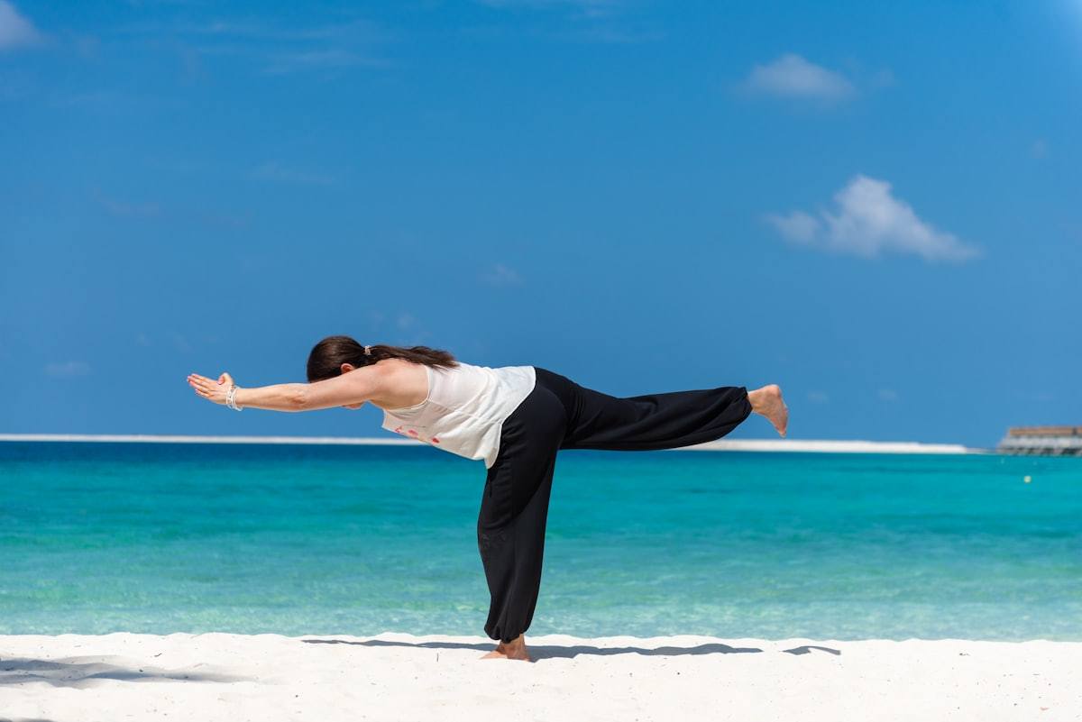 Entorno de yoga en una playa tropical que ilustra una actividad de bienestar en clima cálido