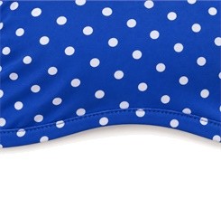 Close-up of stitching along the curved lower edge of the blue polka dot yoga bra