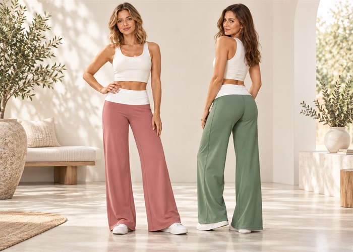 Two women wearing rose and sage green wide-leg yoga pants with white tops in a sunlit interior