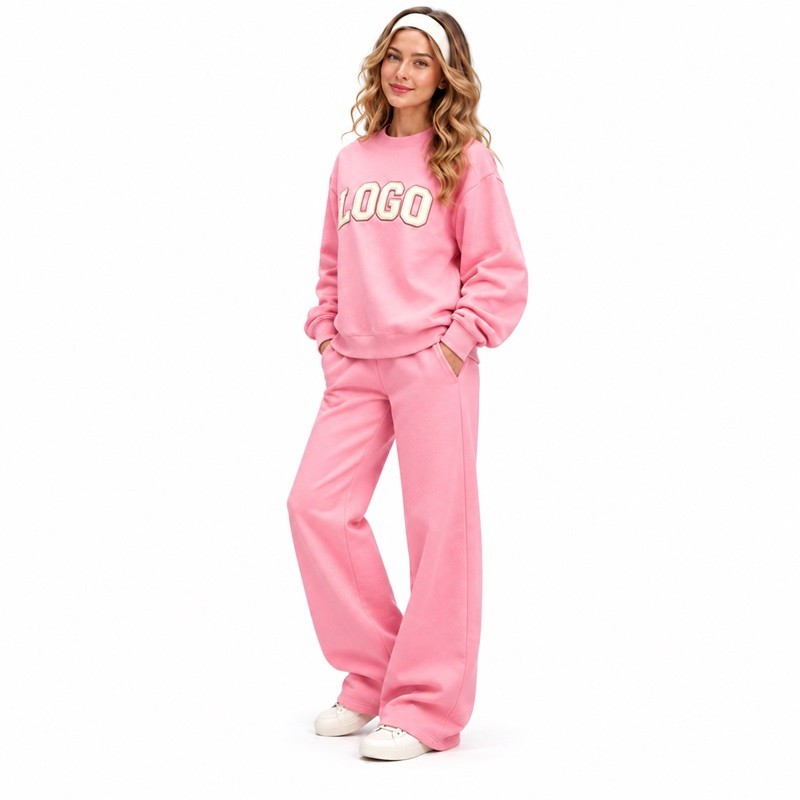 Model wearing pink wide-leg sweatpants with side pockets and matching crew neck sweatshirt