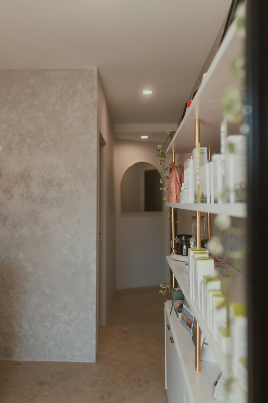 Clean minimal retail interior with a wall shelf of white skincare packaging
