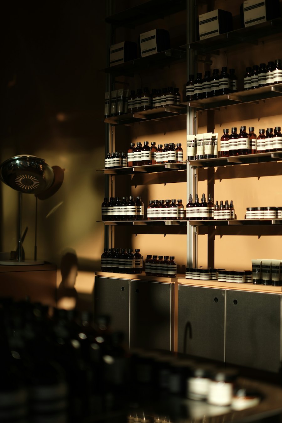 Warmly lit beauty retail interior with backlit shelves of skincare bottles