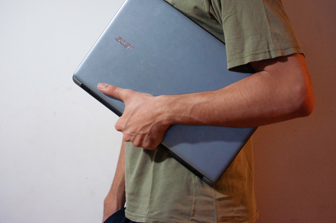 A person sliding a laptop into a leather sleeve