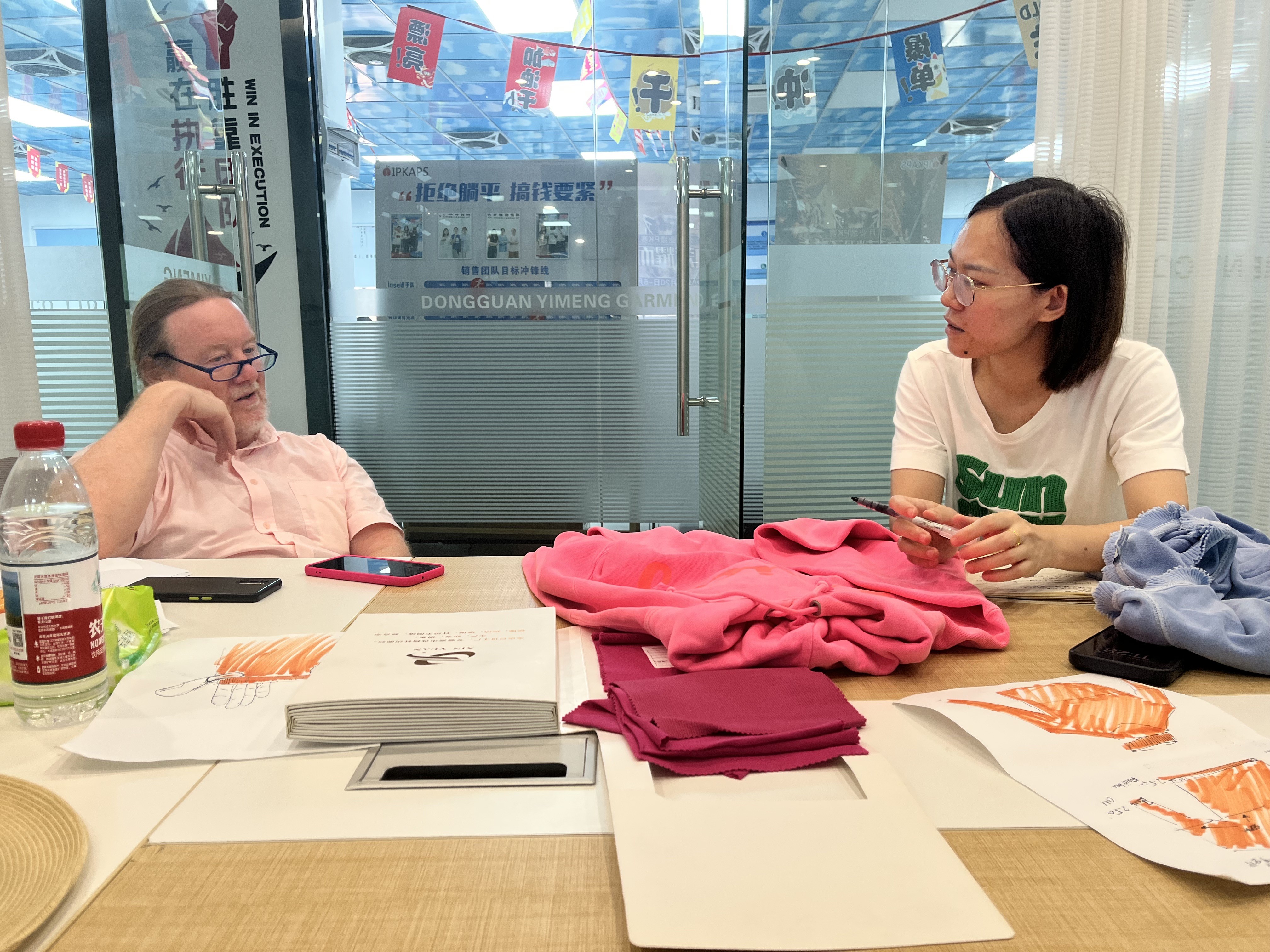 Customer and VANRD team reviewing jacket samples in the showroom during a factory visit