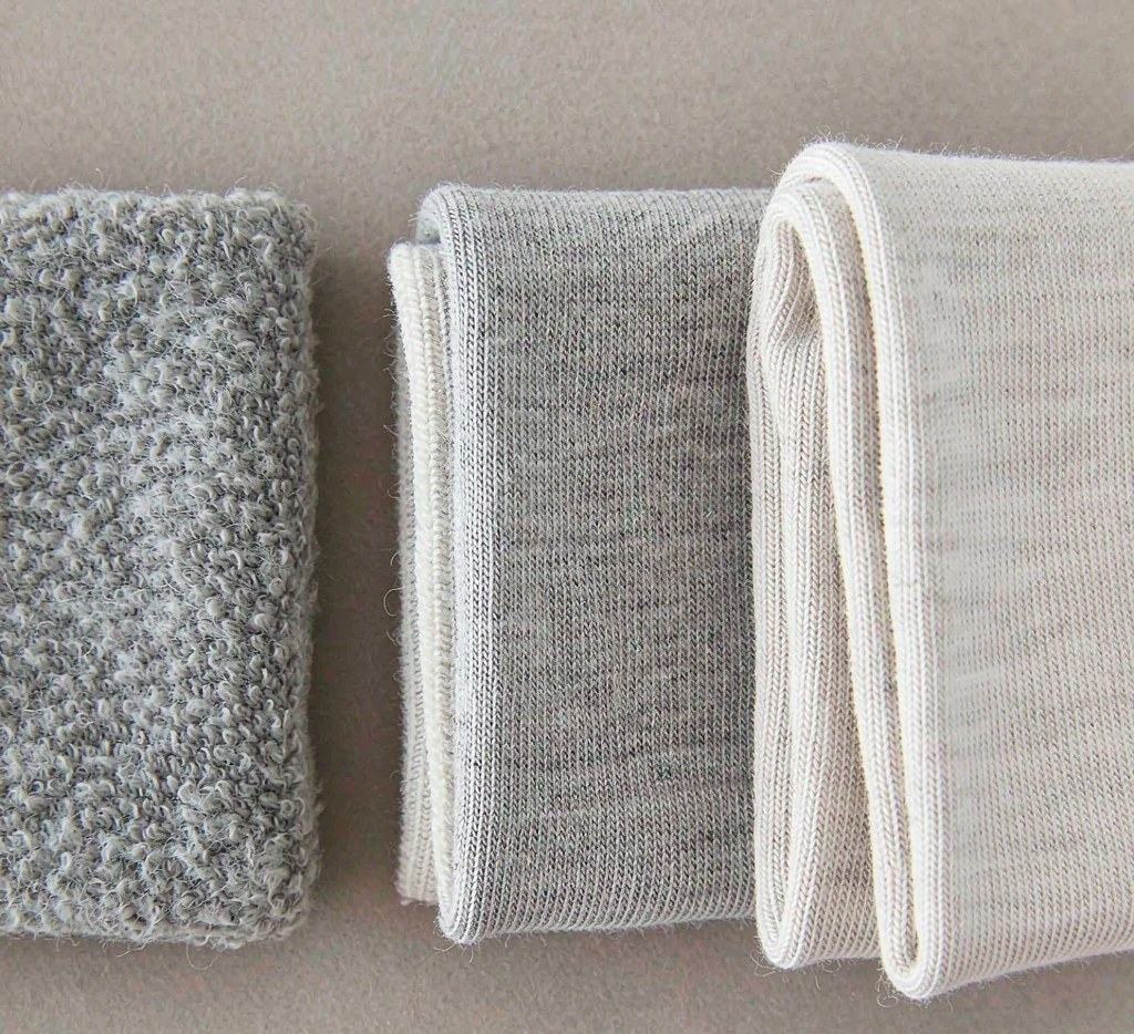 Close-up of grey and cream knit swatches showing different surface and reverse-side textures