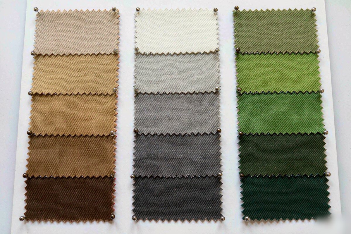 Apparel factory fabric color card showing three columns of cotton duck canvas and heavy twill swatches in brown, gray and olive green gradients