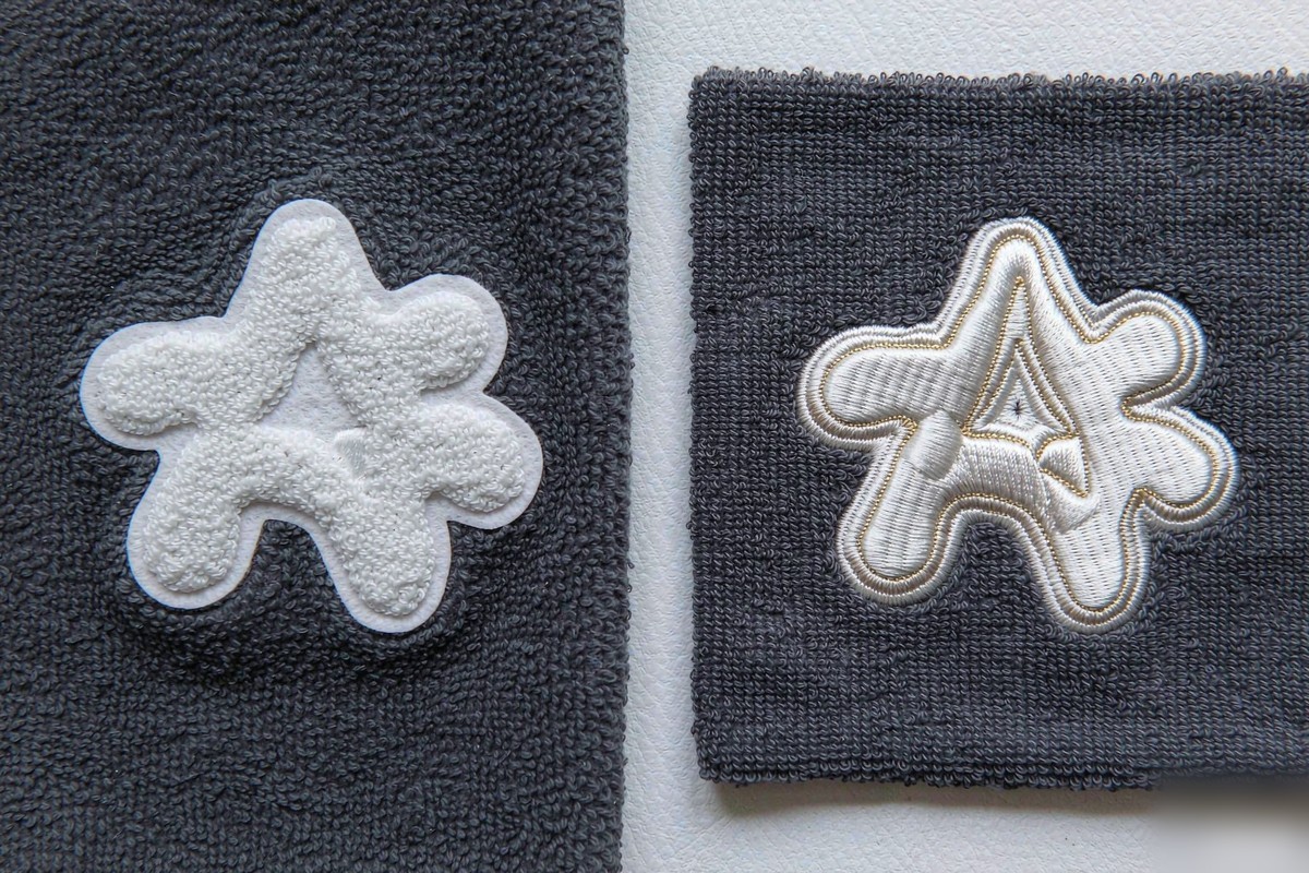 Close-up comparison of hoodie graphic decoration and embroidery details on knit fabric