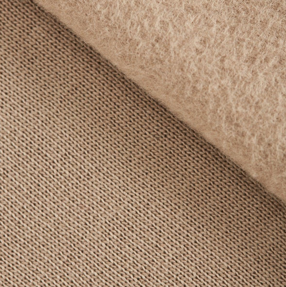 Close-up of brushed sweatshirt fleece with a soft raised nap next to its smooth knit outer face