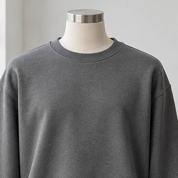 Close-up of the grey crewneck sweatshirt neckline, shoulder seam and fleece construction
