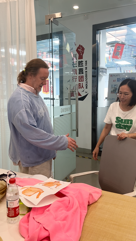 Customer trying on a washed sweatshirt sample to check fit, drape, and sizing before bulk production