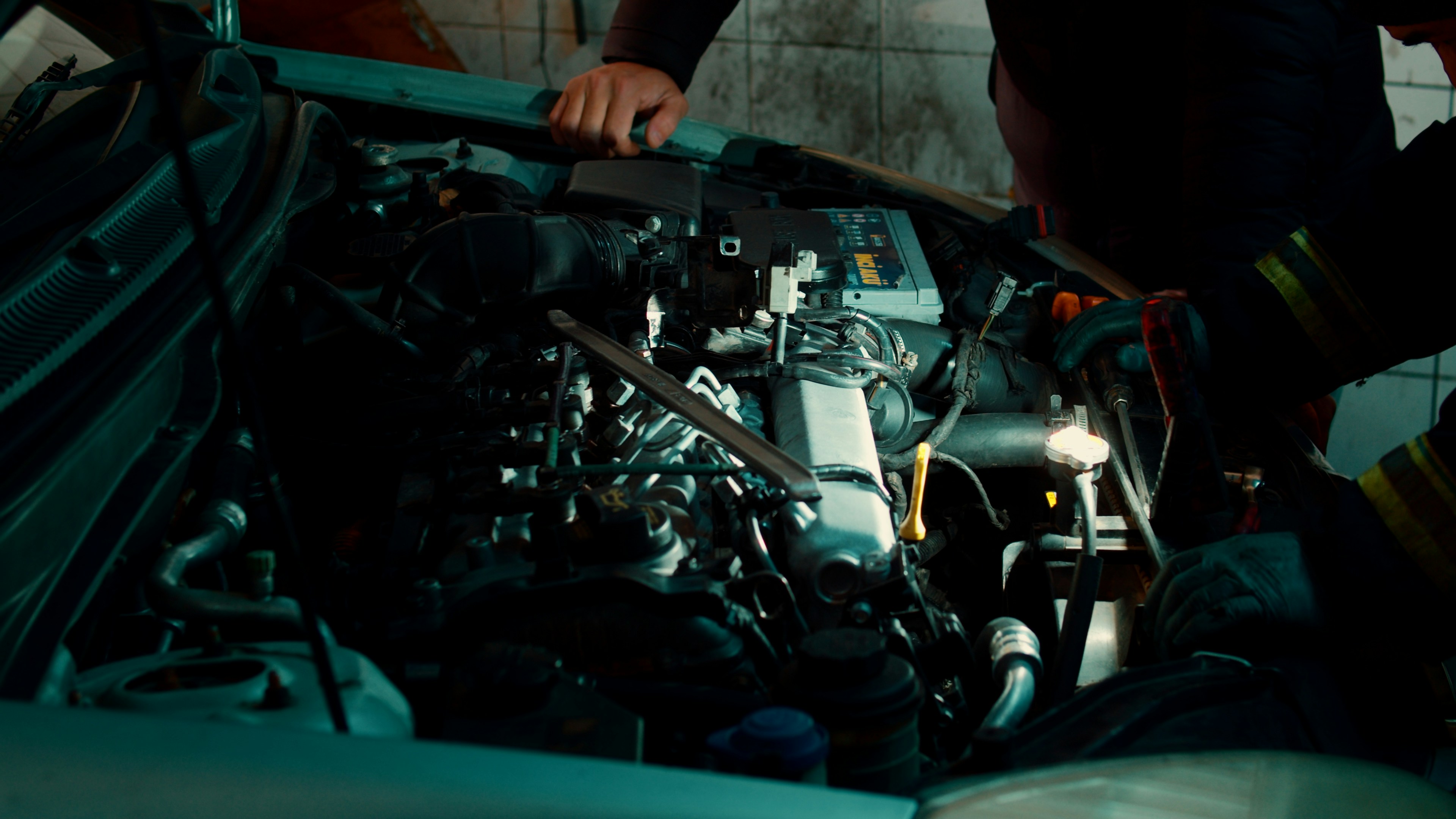 A high-lumen inspection light illuminating a car engine bay