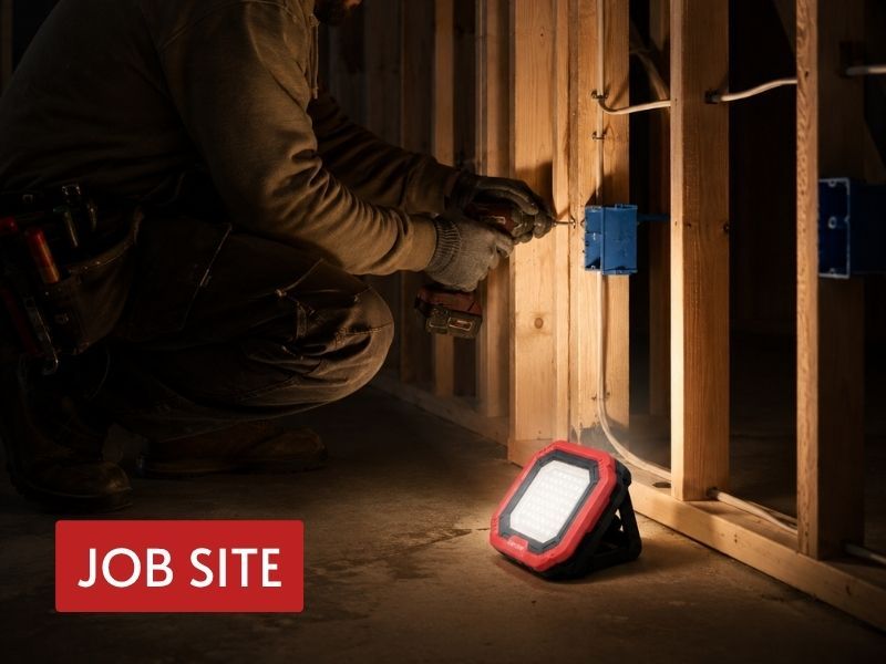 rechargeable led flood lamp lighting an electrician working inside a framed wall at a jobsite