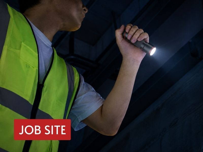tactical pocket flashlight used for overhead inspection in a dark industrial jobsite