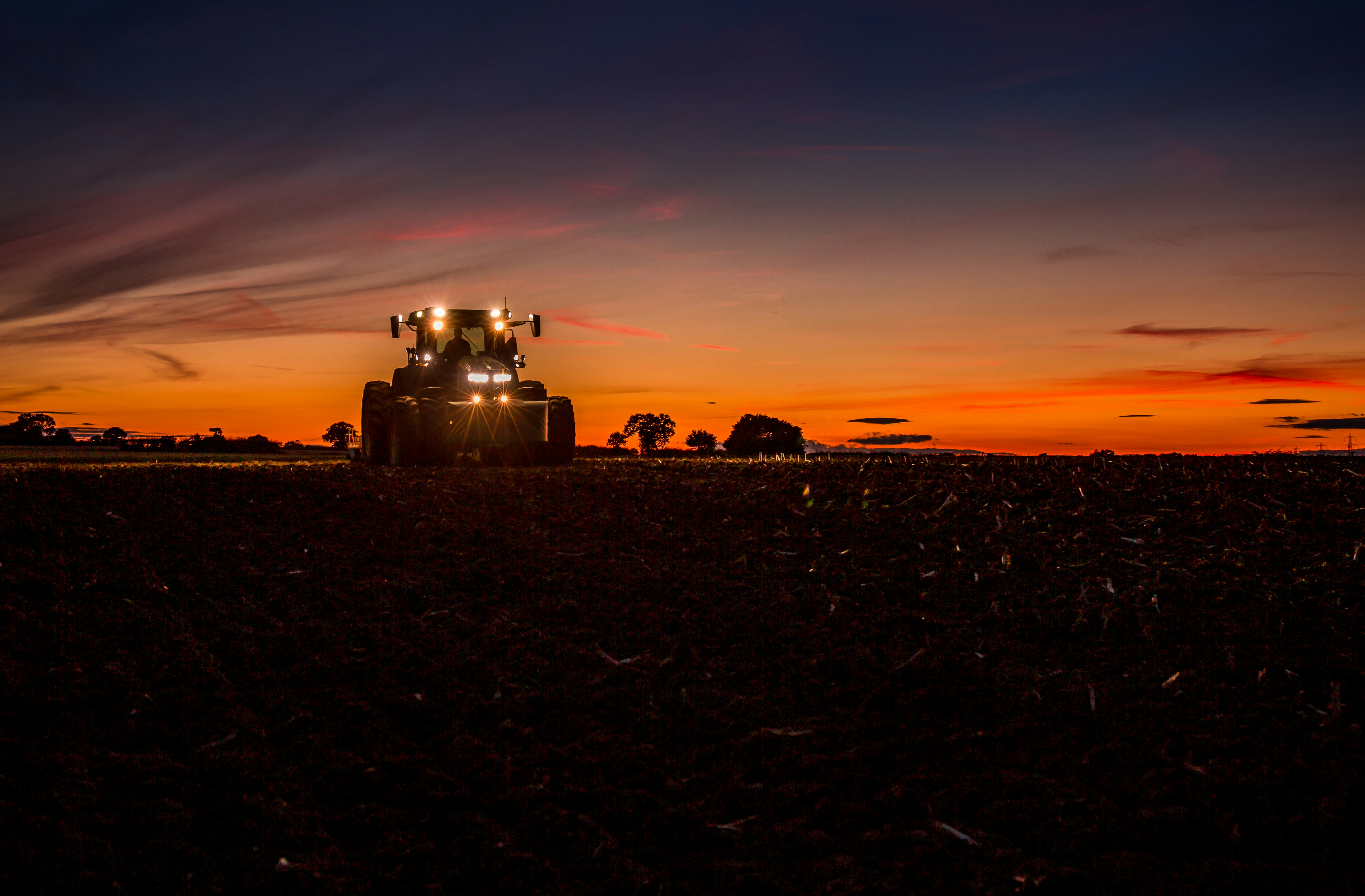 LED Work Lights on Combine Harvester A combine harvester with multiple LED work lights operating in a field at night.