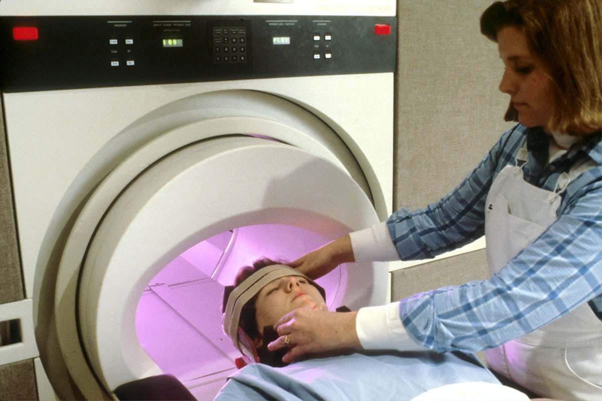 MRI technologist preparing a patient for imaging