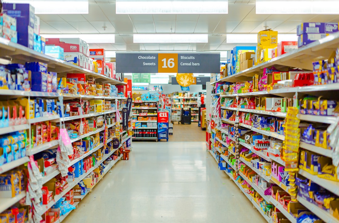 A plastic sign clip attached to a supermarket shelf displaying a 'Special Offer' tag