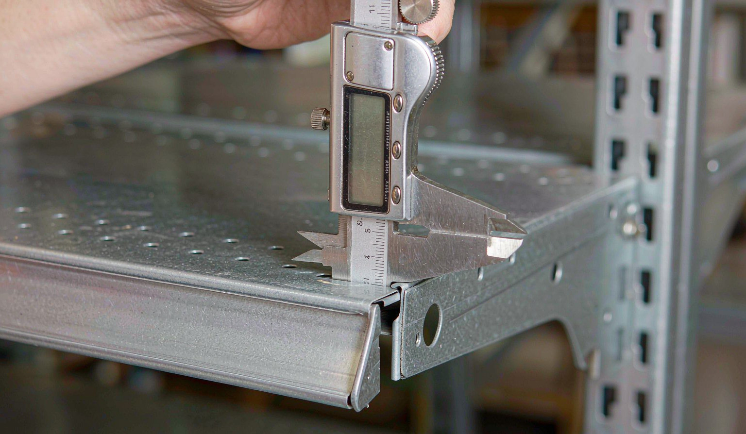 Vernier caliper measuring the thickness of a metal shelf front edge