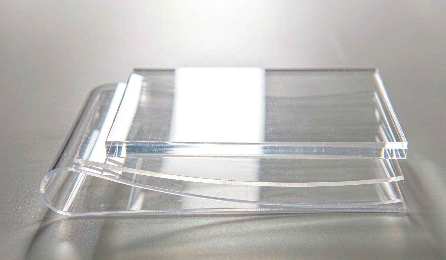 Clear plastic shelf labelling profiles stacked together as material samples on a neutral surface