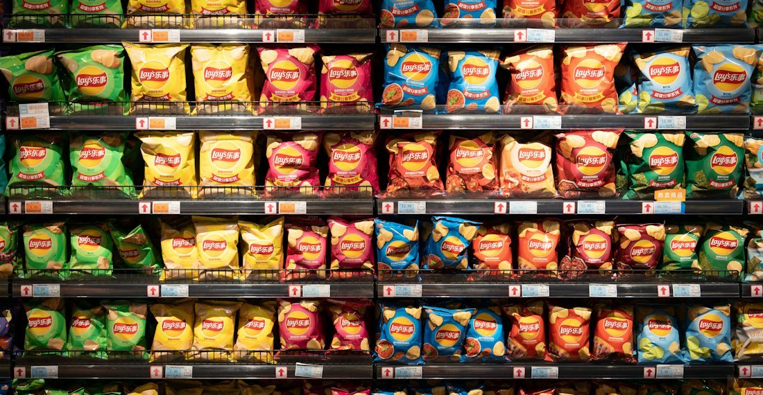 Dense chip wall where clip-on dividers separate flavors and pack sizes into distinct lanes