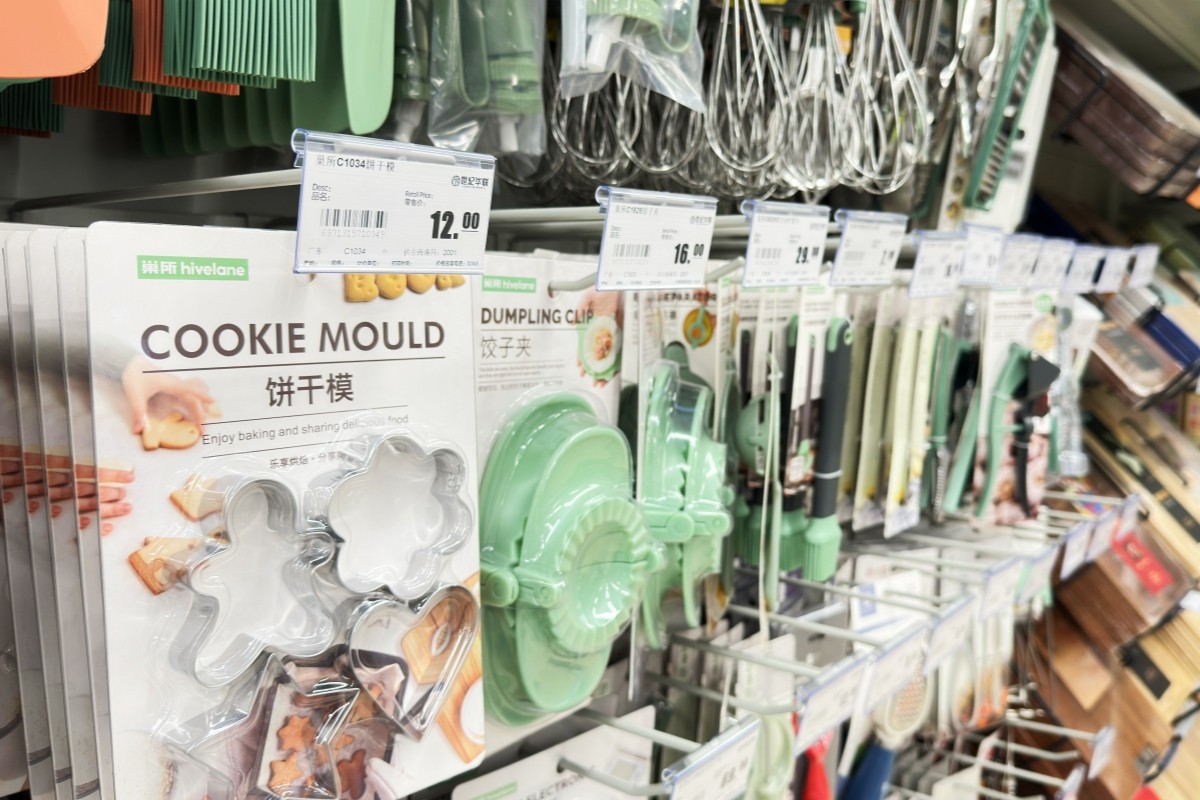 Carded kitchen tools including cookie moulds, dumpling presses and whisks hanging from white double-wire hooks with label holders
