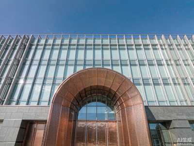 Water-based FEVE fluorocarbon topcoat protecting a modern building with copper door and aluminum curtain wall