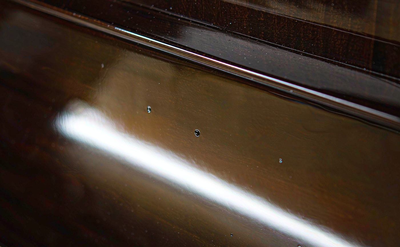 High-gloss clear UV varnish film cured on a dark surface