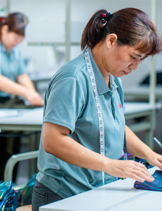 Factory worker performing rigorous AQL 2.5 quality control inspection on activewear garments.