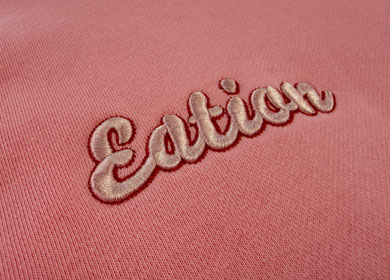 High-density custom embroidery detail on heavy pink fabric, ideal for hoodies and joggers private label.