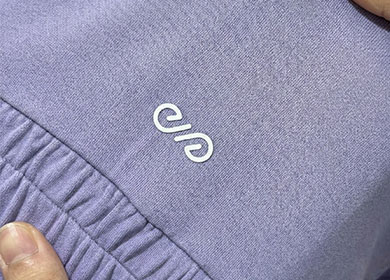 Durable heat transfer logo printing on stretchable purple activewear fabric for custom sportswear.