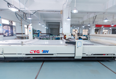 Skilled worker operating automated fabric cutting machine for custom sportswear production, maximizing efficiency.