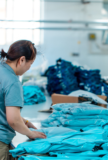 Skilled worker performing final quality control and packaging for premium activewear orders, ready for global shipping.