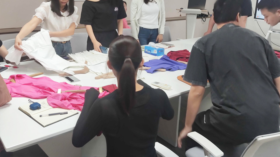 Product team at Call The STYLE examining white tennis and pickleball clothing samples.