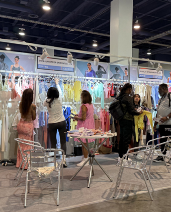Busy custom activewear manufacturing booth meeting global buyers at US Apparel Expo 2025.