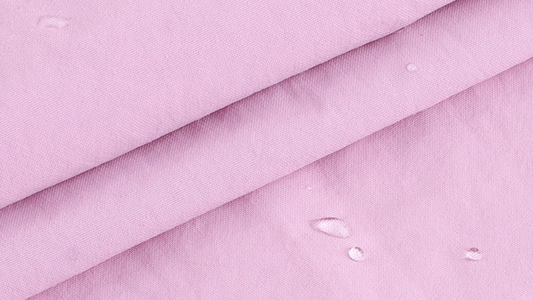 Premium PFAS-free activewear fabric showing C0 DWR water repellent beading effect