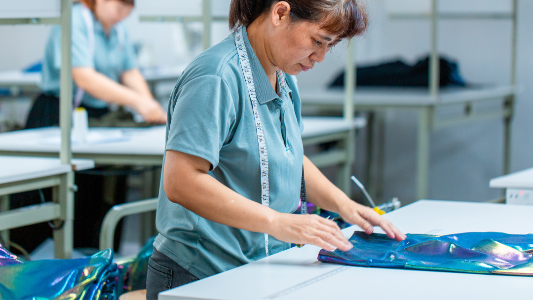 Quality control inspector measuring premium activewear fabric on the factory floor