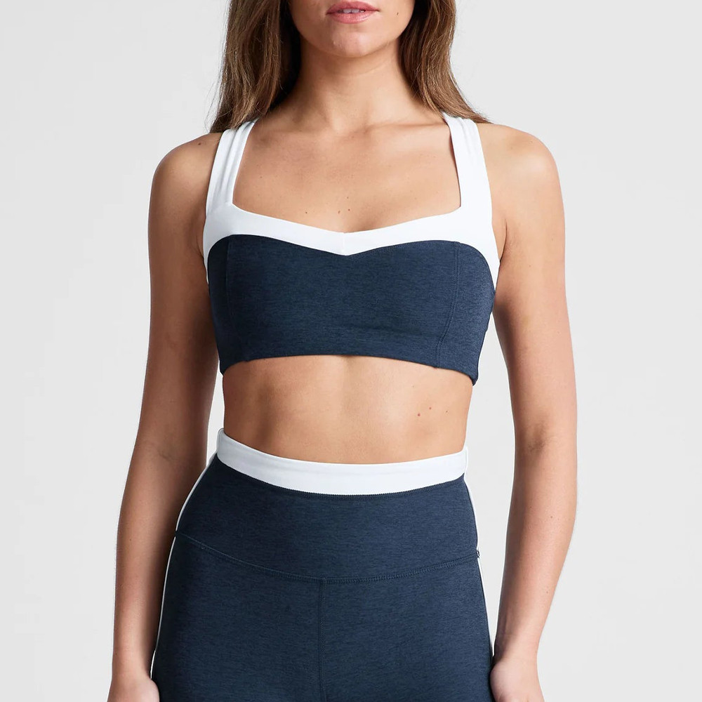 Close-up of the front neckline and white contrast panel on a 75/25 nylon-spandex workout bra, crafted by a custom sports bra factory.