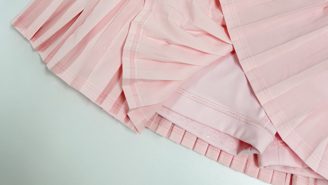 Details of pleated tennis skirt showing heat-set folds and built-in inner shorts