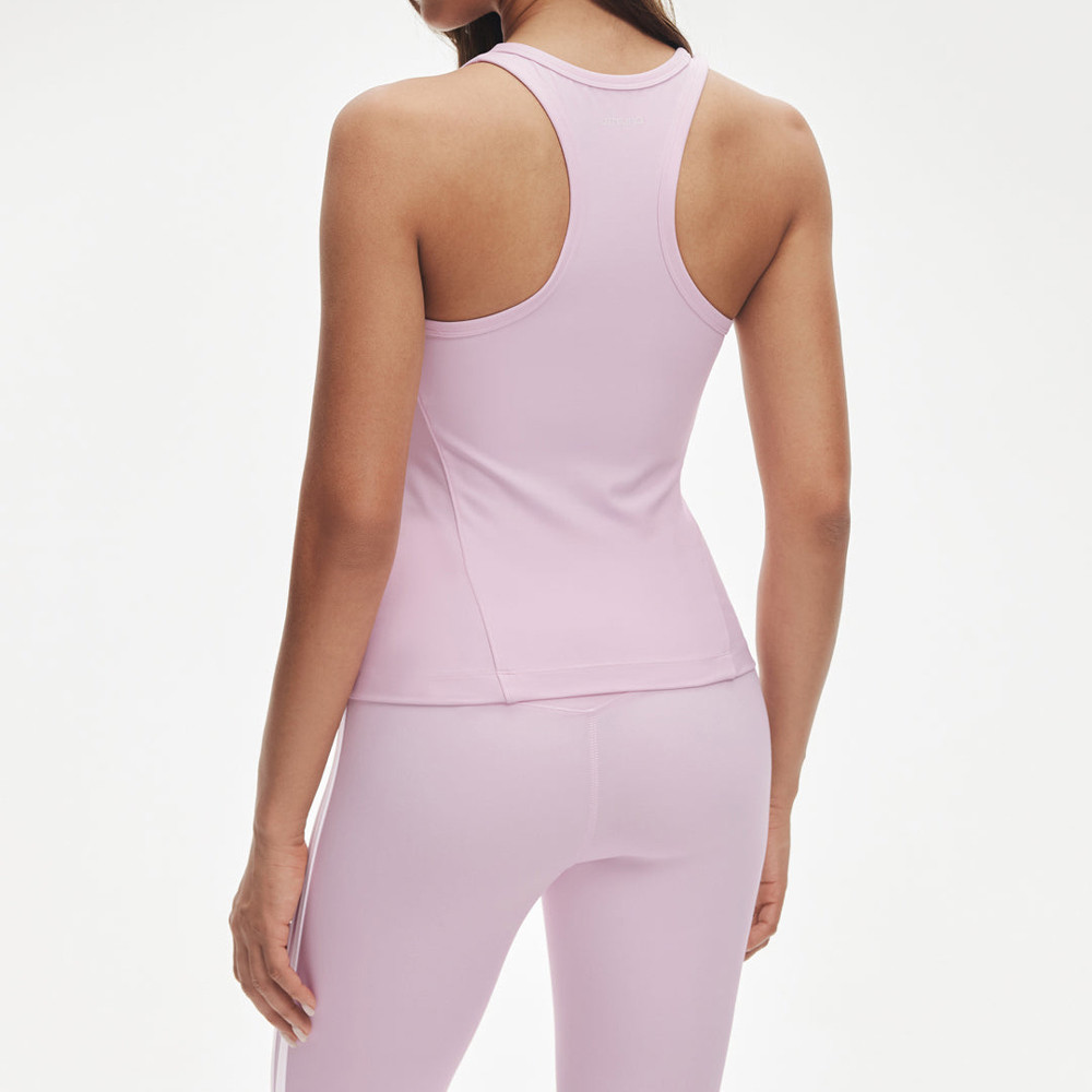 Rear view demonstrating the racerback cut and fitted waist on a pink workout tank top.