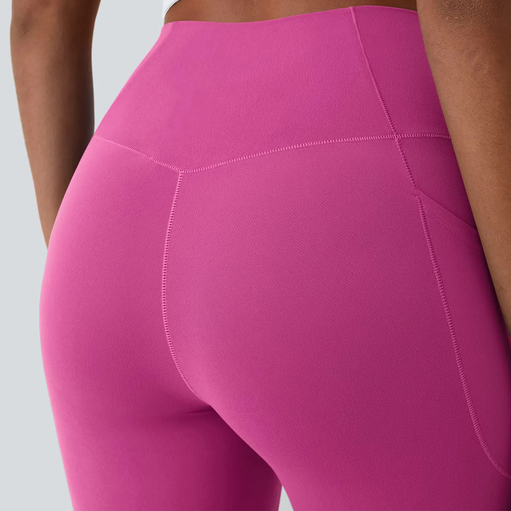 Rear mid-shot highlighting the V-shaped back yoke seam on pink high stretch workout leggings.