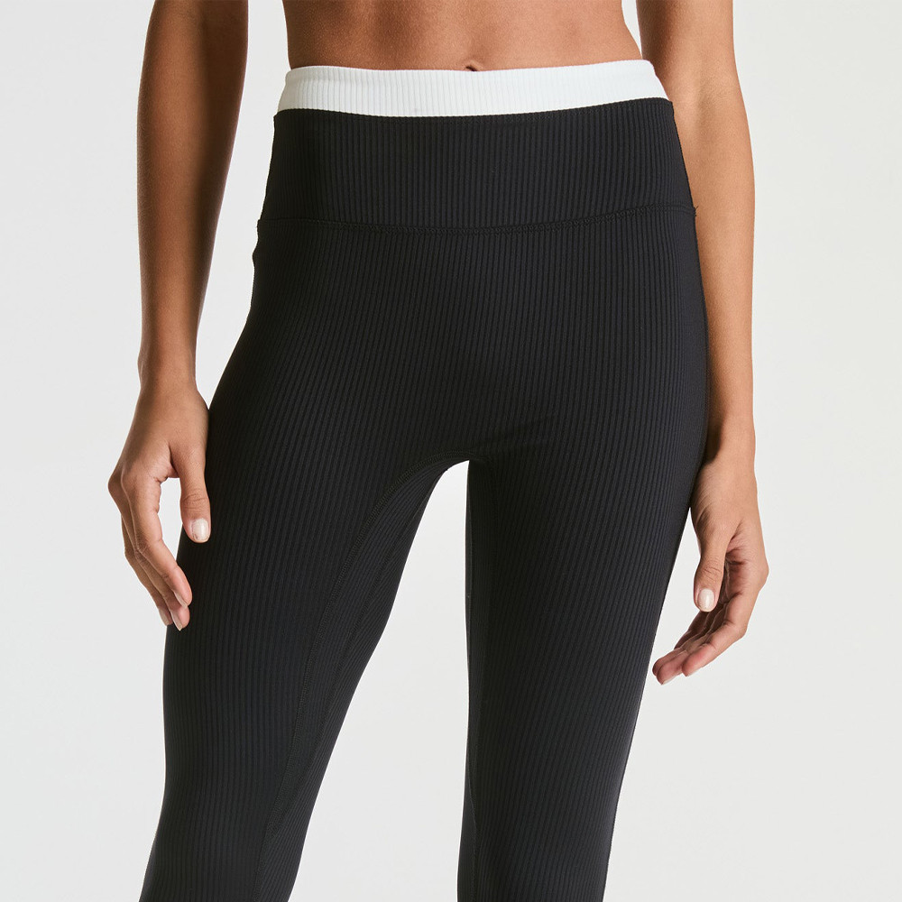 Front mid-shot focusing on the double-layer color block waistband of black ribbed workout leggings.