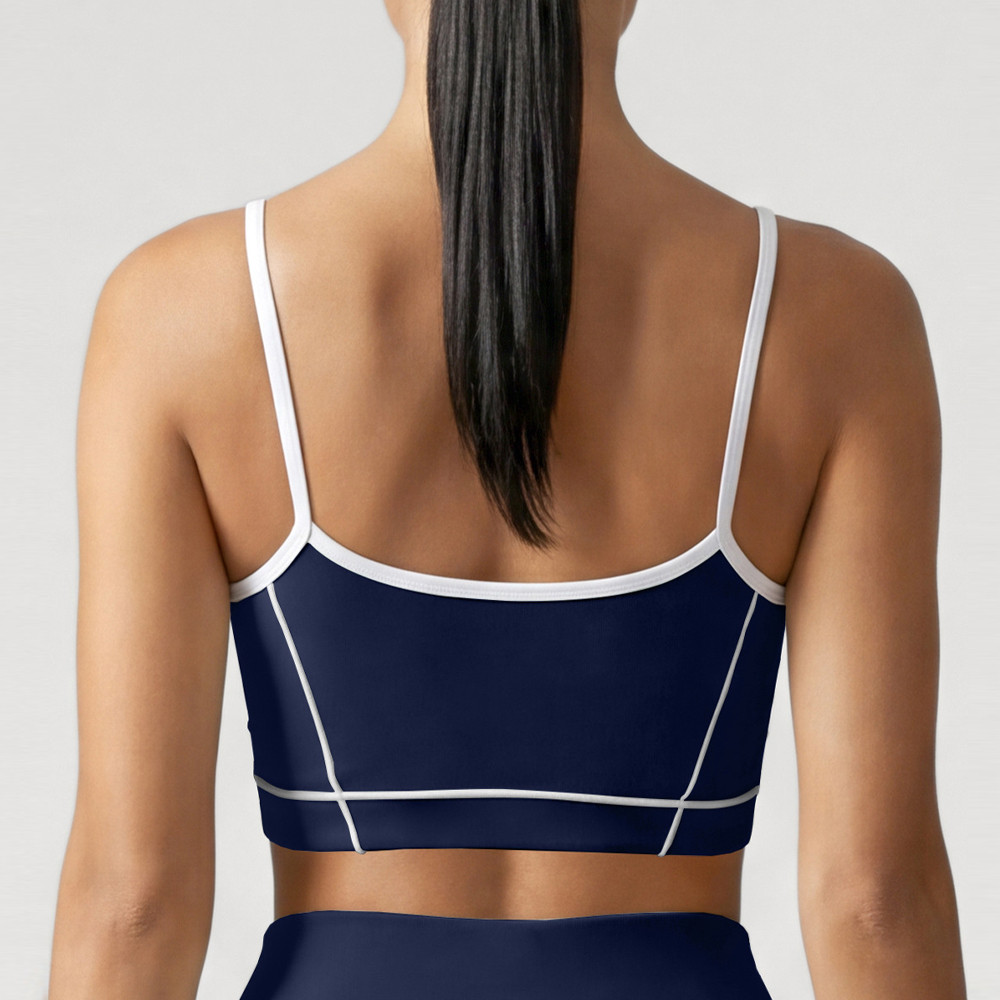 Rear close-up showing the back panel and piping details on a navy blue workout sports bra.
