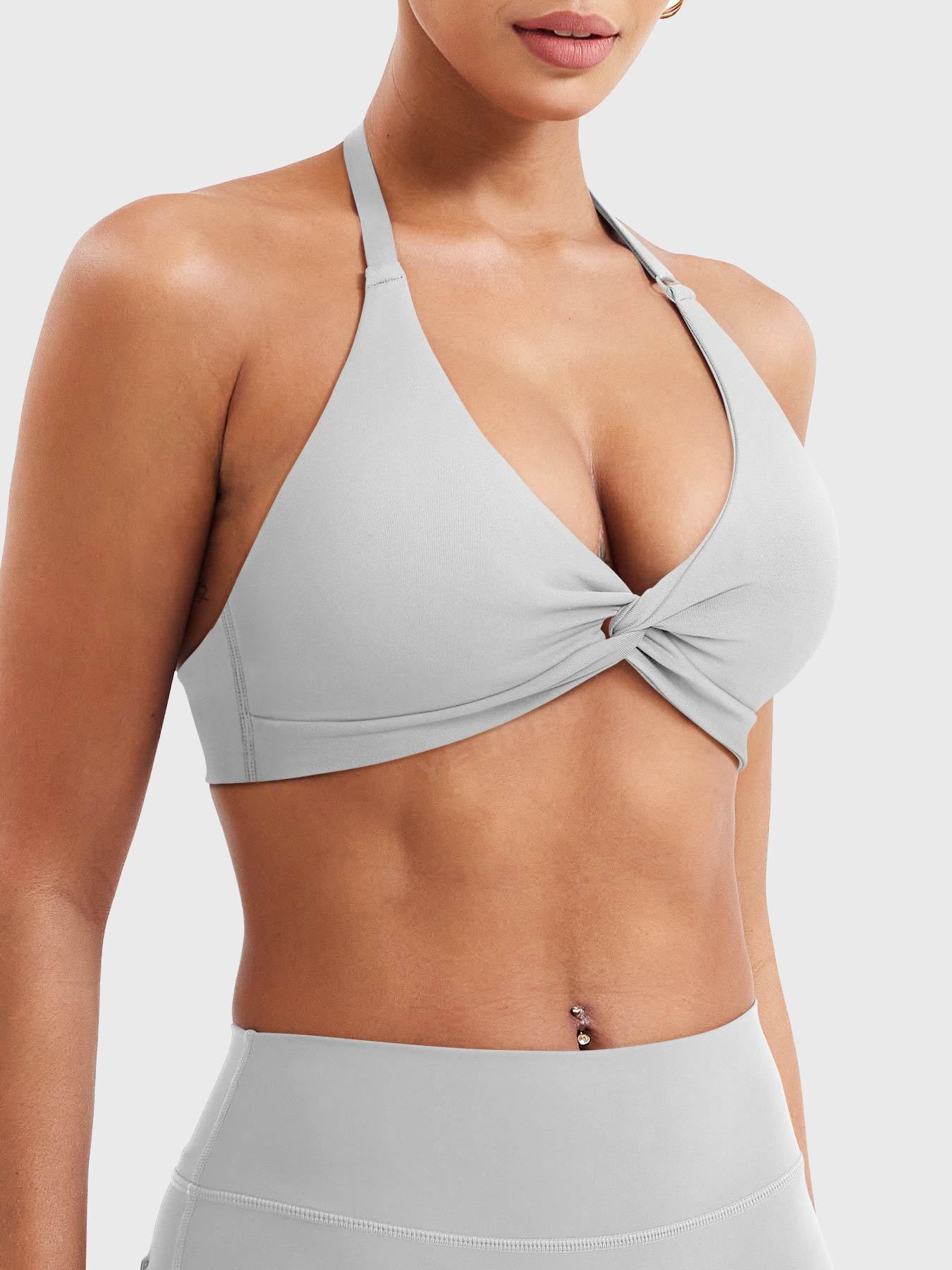 Close front view of light gray halter sports bra showing deep V neck twist front panels lower band and adjustable strap hardware