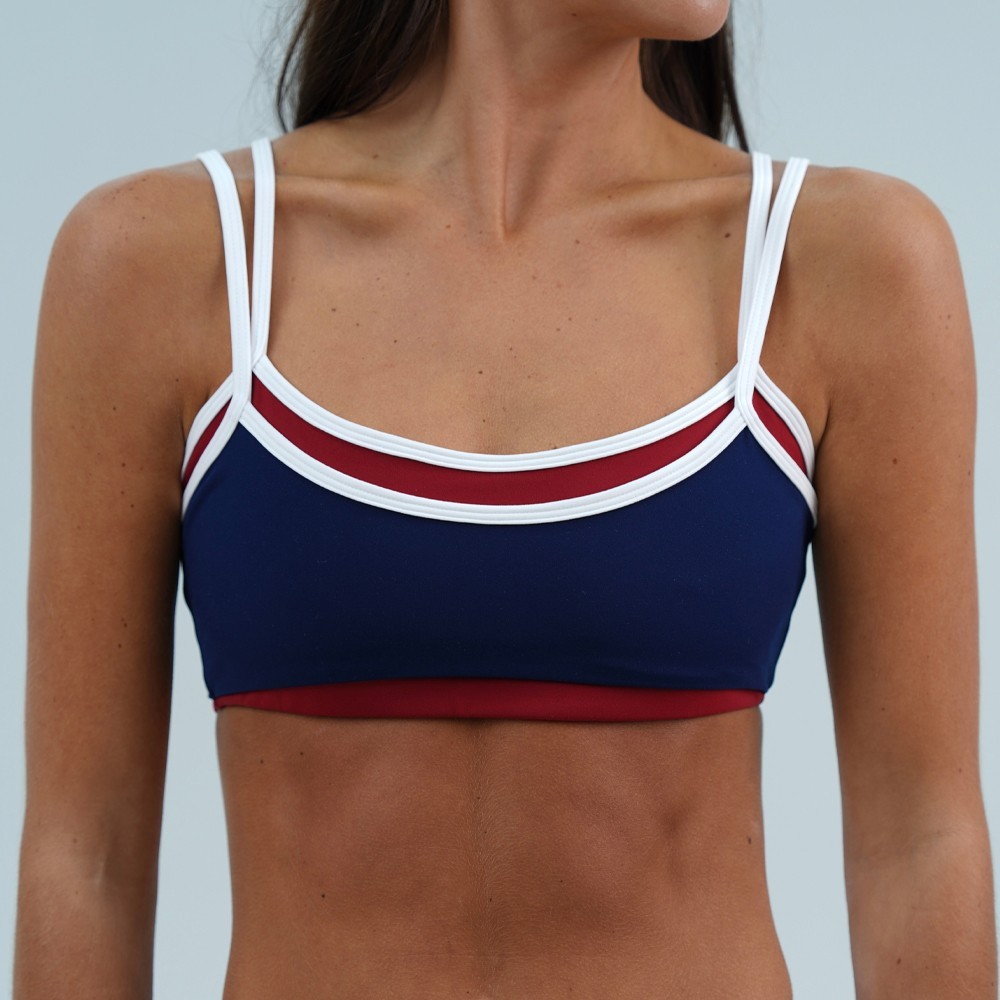 Front view of navy and red double layer U neck sports bra on model showing layered collar and adjustable straps
