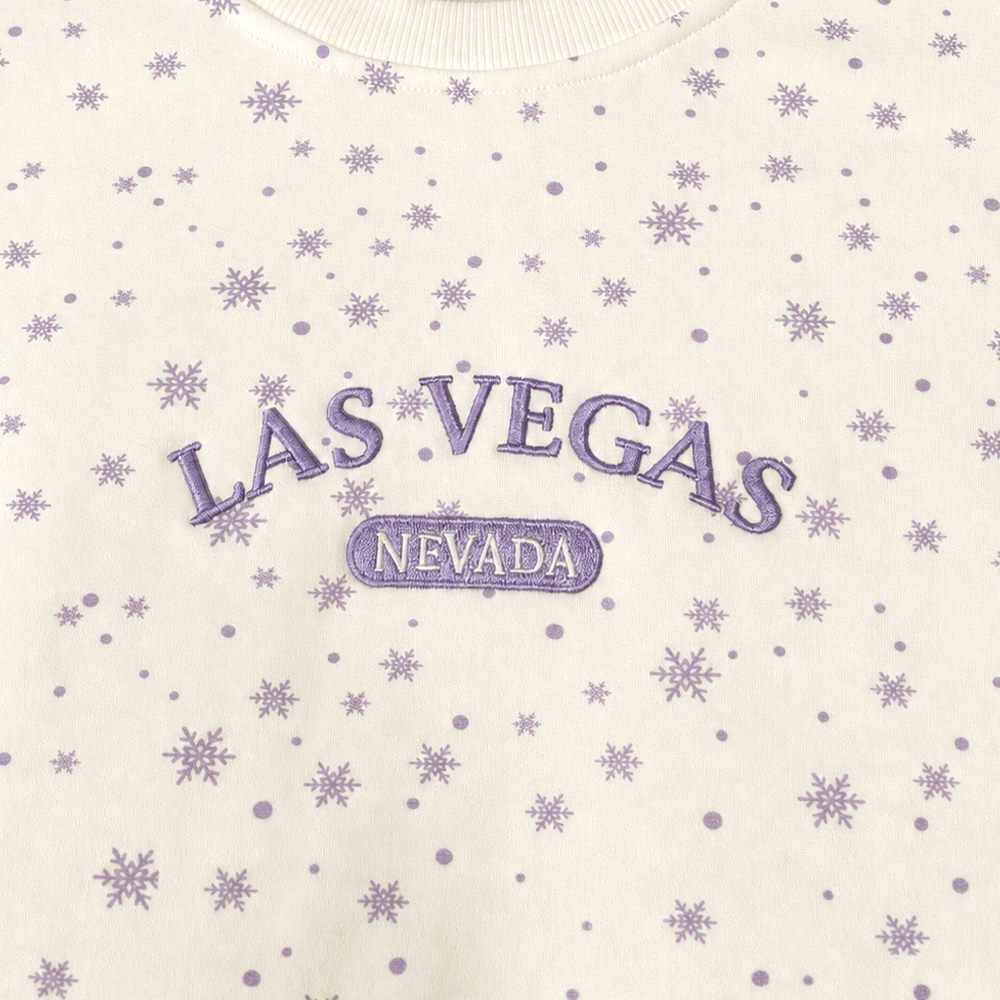 Close view of sample embroidered letter detail on snowflake print fabric