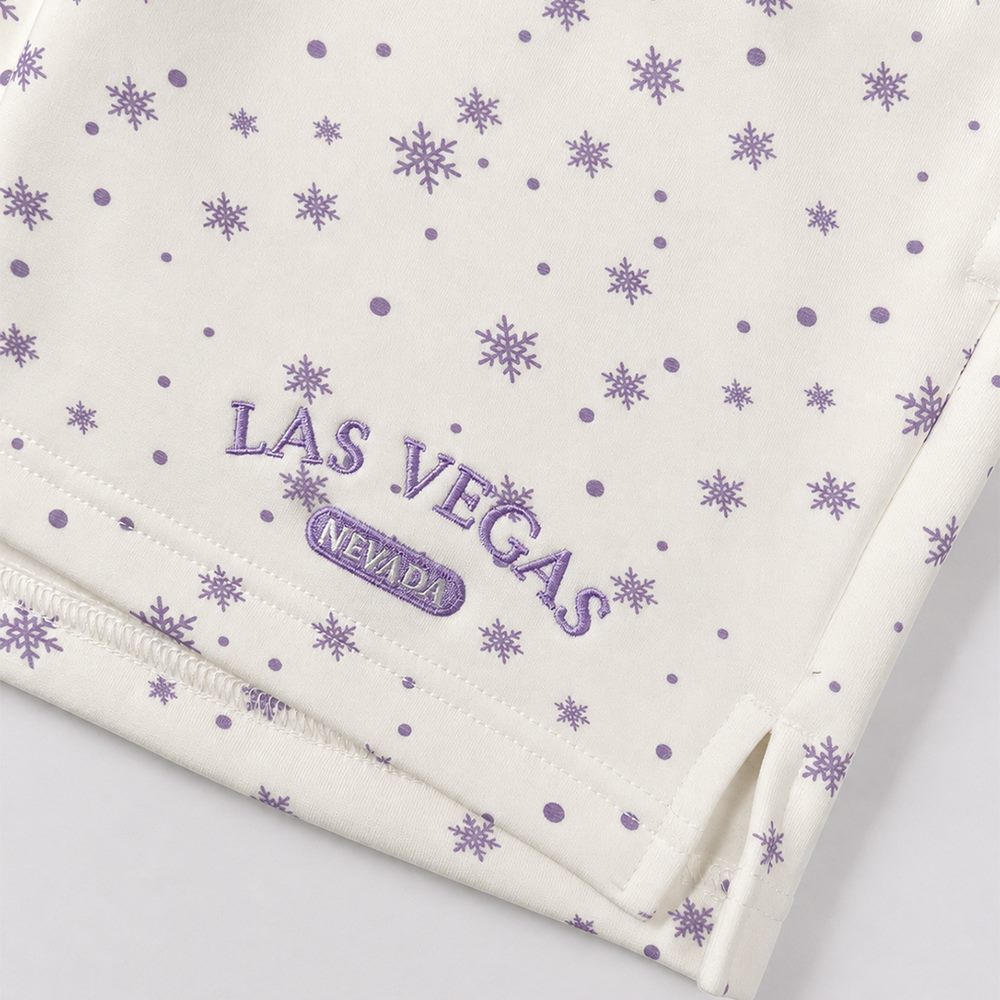 Close view of side slit and embroidered letter detail on printed shorts