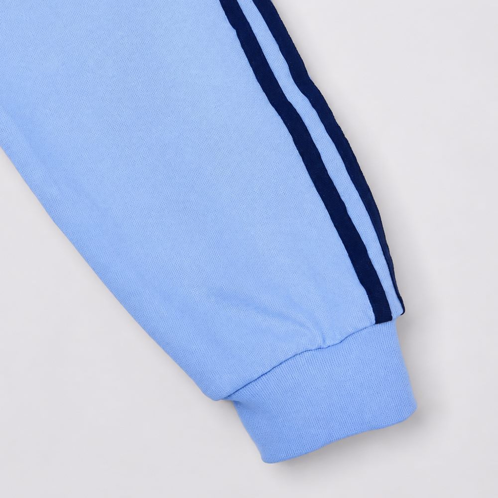Close view of contrast woven tapes and ribbed cuff on sleeve