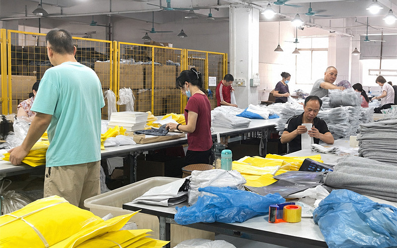 Workers sorting garments and packing materials in the finishing area