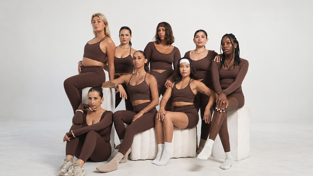 Women wearing coordinated brown activewear sets including leggings sports bras and shorts