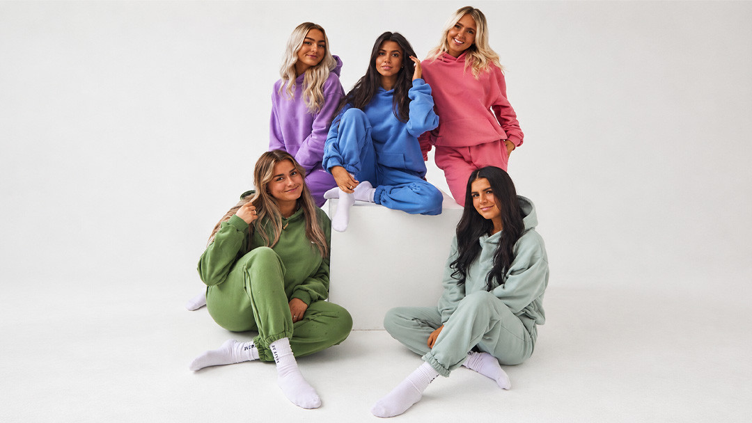 Women wearing colorful coordinated hoodie and jogger sets in multiple colorways